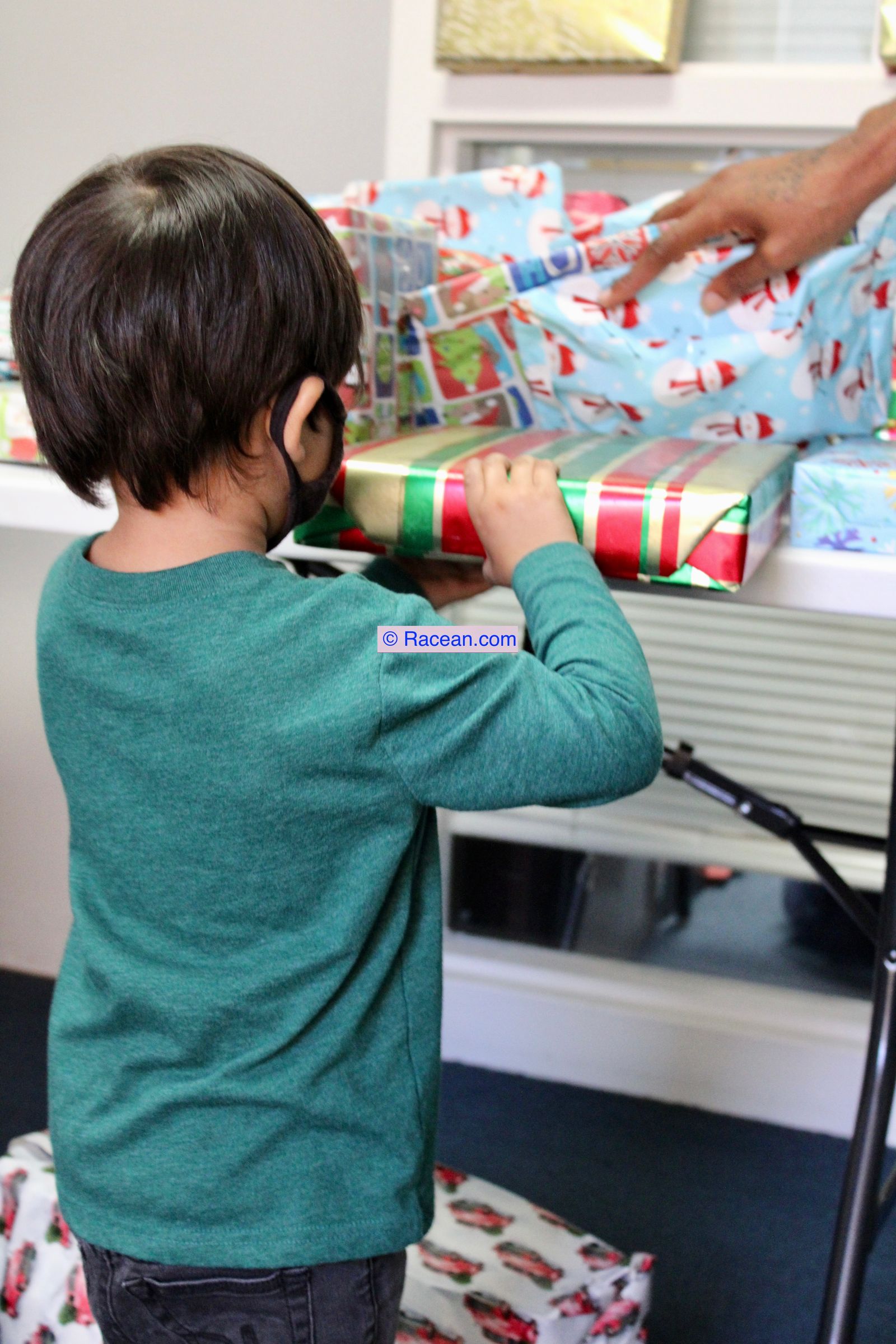 A child reaching for a wrapped gift